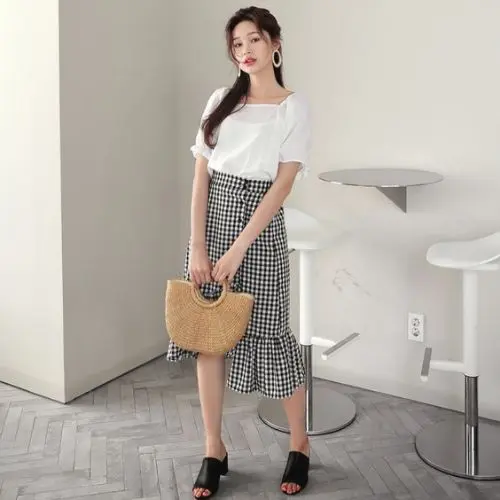 outfit coreano para mujer con falda a cuadros y volantes y playera blanca