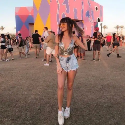 Outfit de mujer para Coachella con blusa plateada y shorts