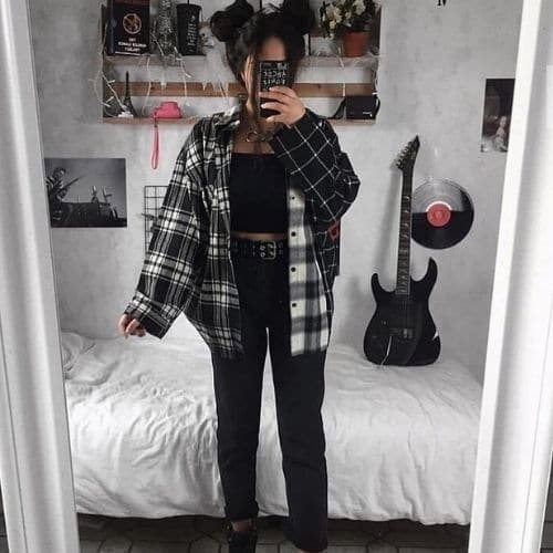 Outfit grunge de mujer con camisa a cuadros y jeans negros