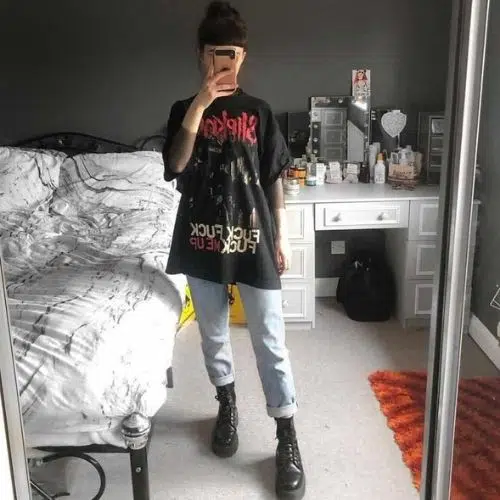 Outfit grunge con playera estampada, jeans y botas negras