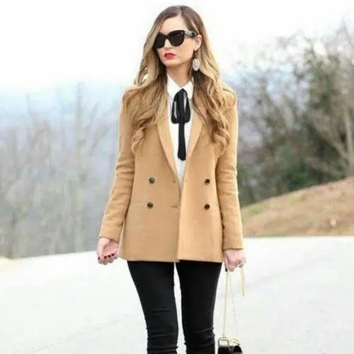 Outfit para oficina para mujer con blazer beige, blusa con lazo negro y pantalón negro